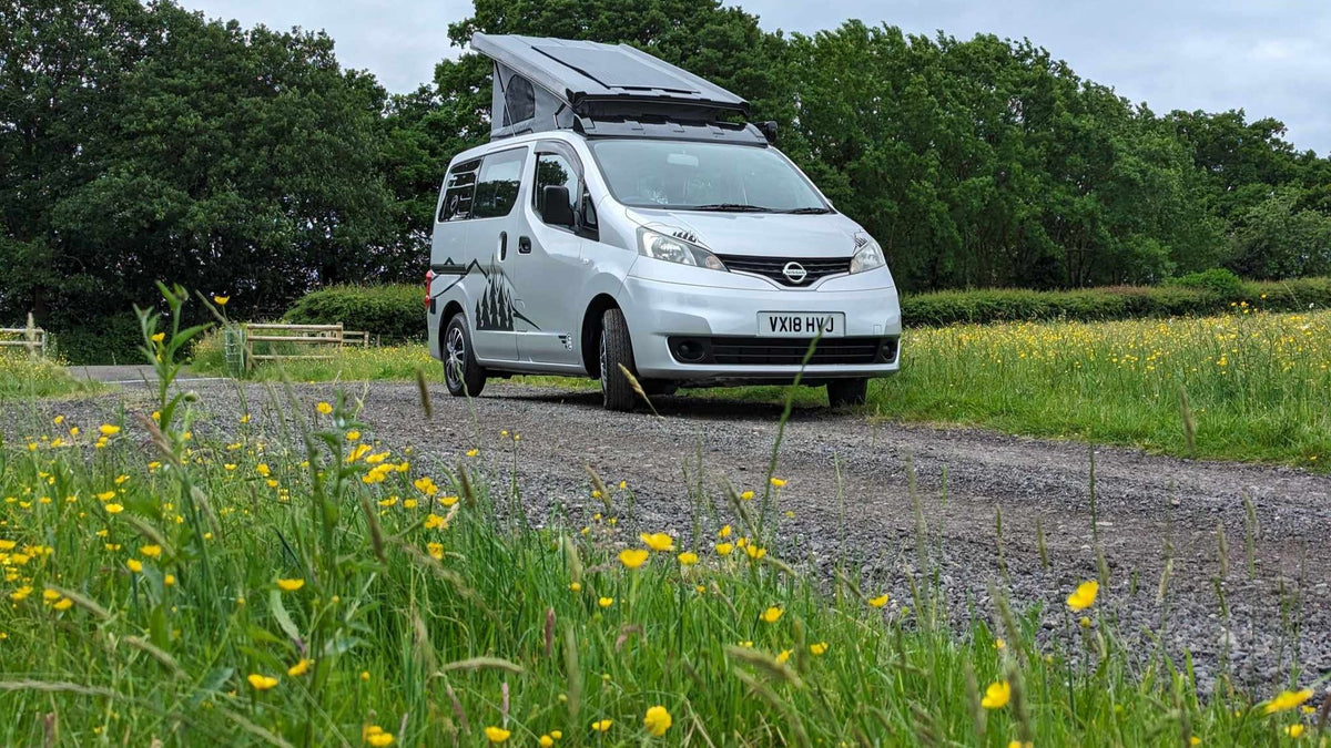 White Nissan NV200 camper van conversion with front grille and headlights visible