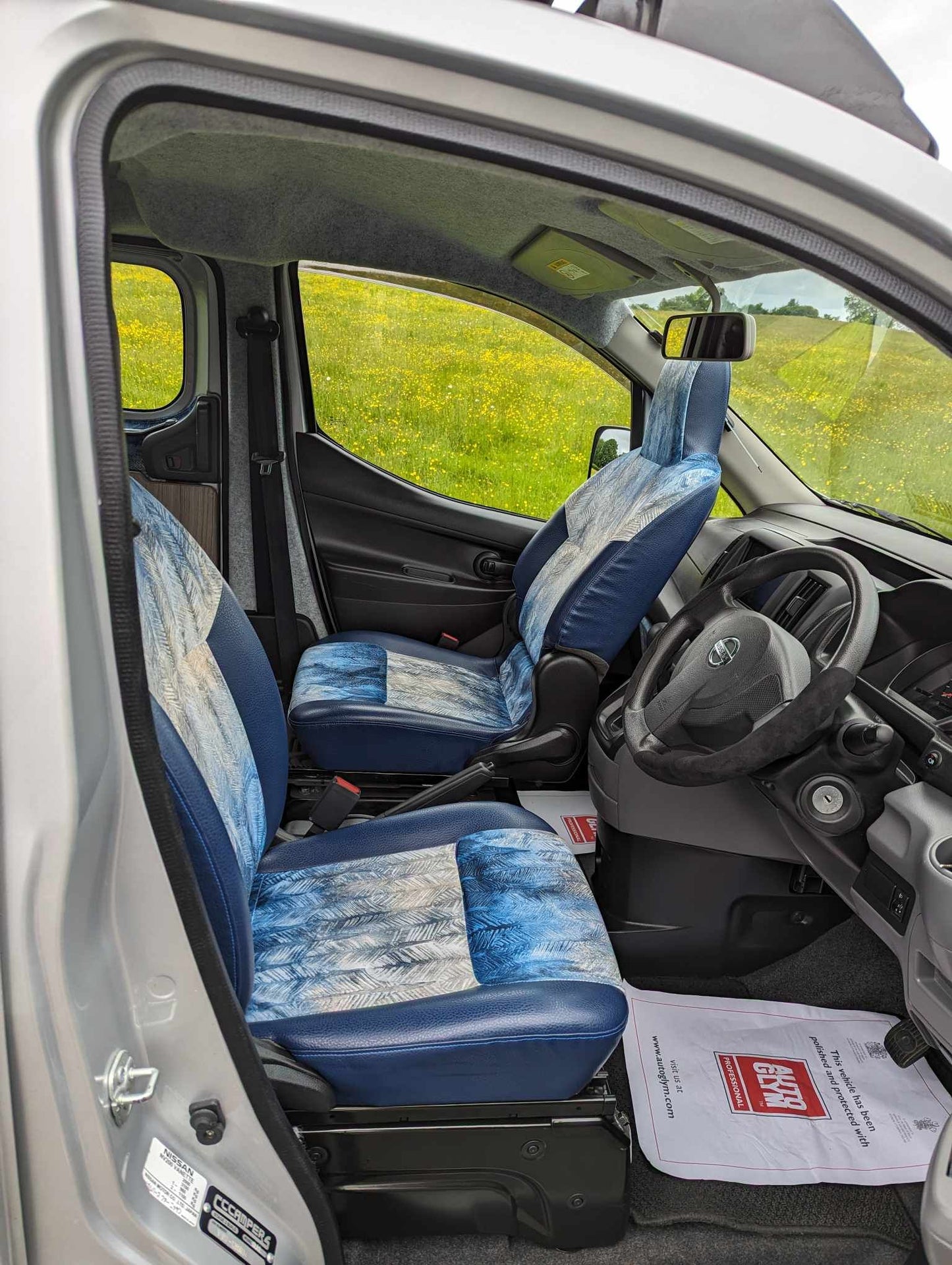 Nissan NV200 passenger seat swivel setup with blue upholstery and front cab seats
