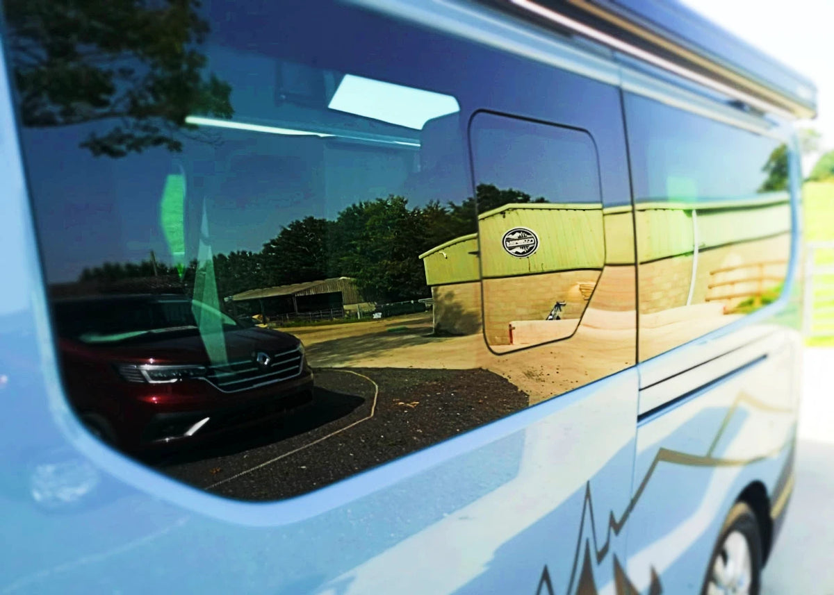 Campervan side window with sliding awning compartment in light blue exterior