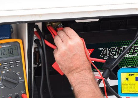 Battery health tester with red and black leads connected to leisure battery