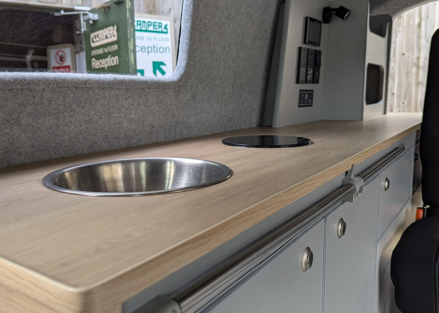 Maxus eDeliver 3 Camper van interior with wooden countertop, sink, and cabinets.