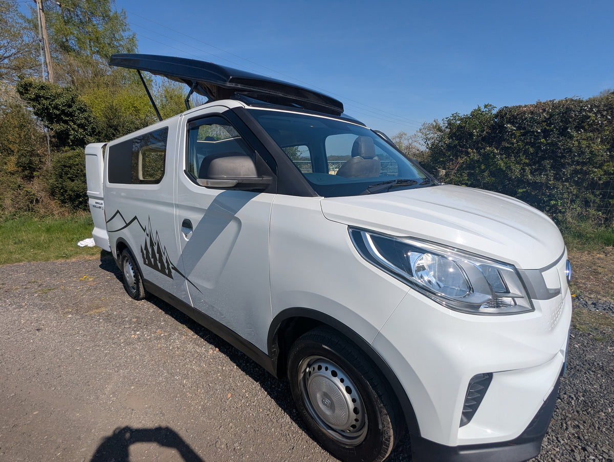White maxus edeliver 3 electric micro campervan front corner with headlights, grille, and open roof vent