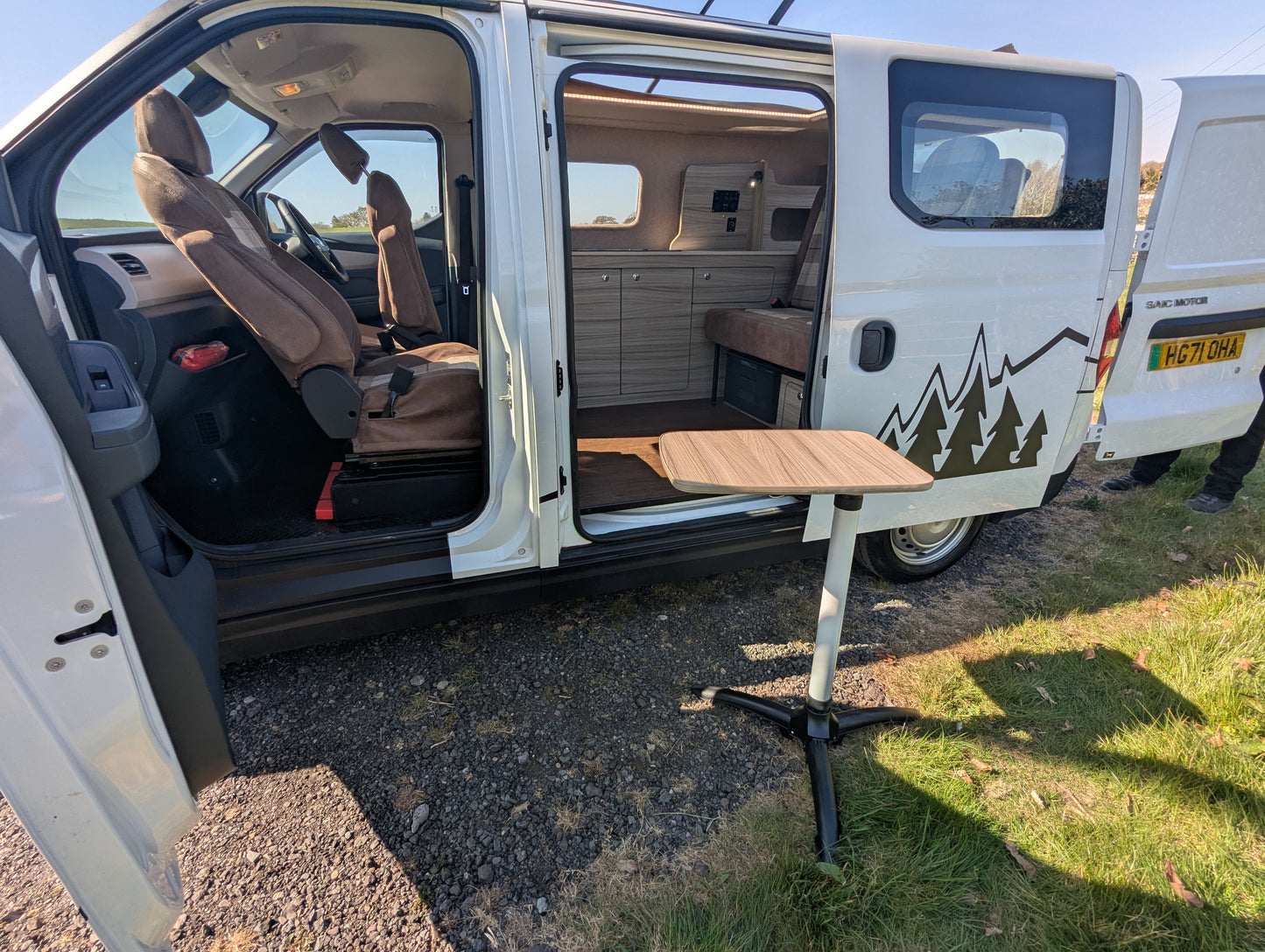 maxus edeliver 3 Electric micro campervan interior with two-seat area and fold-out bed platform