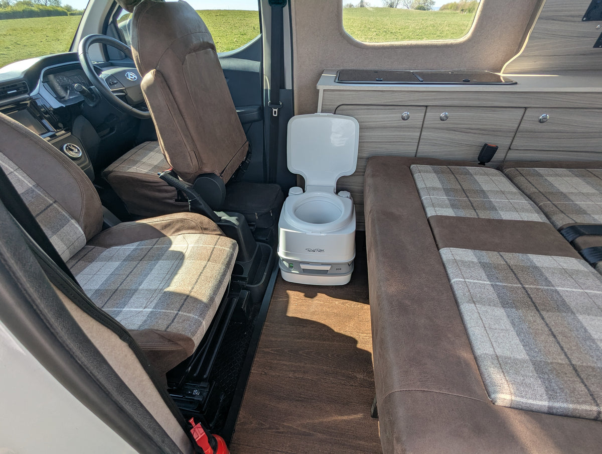 maxus edeliver 3 Maxus eDeliver 3 Camper van interior Electric micro campervan interior with side benches, table surface, and portable toilet