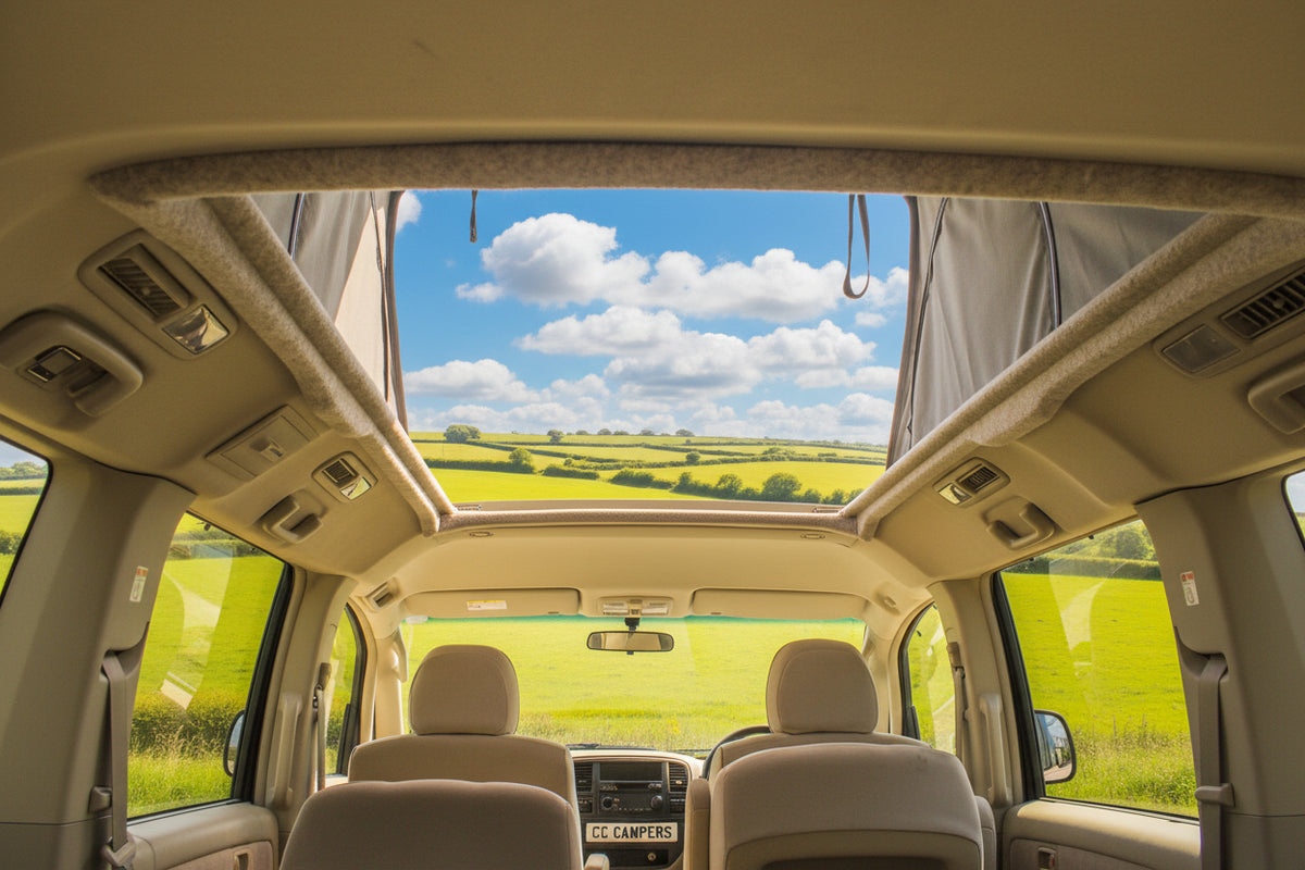 Camper van interior with pop-top roof open above front seats and viewing window