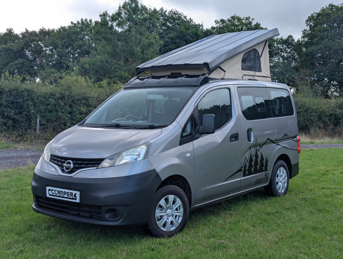 Silver Nissan micro campervan front view with pop-top tent and side graphics