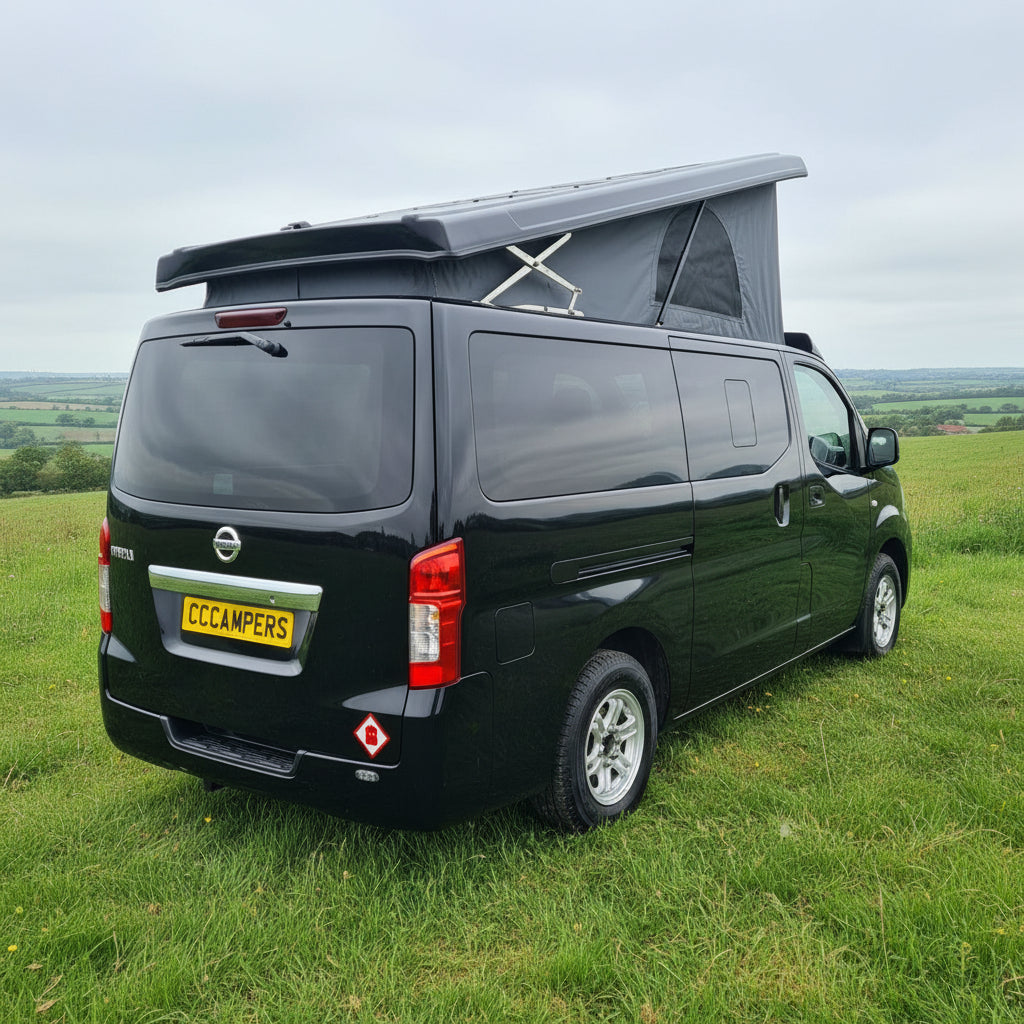 Dark green Nissan NV350 camper van with raised pop-top roof and side profile