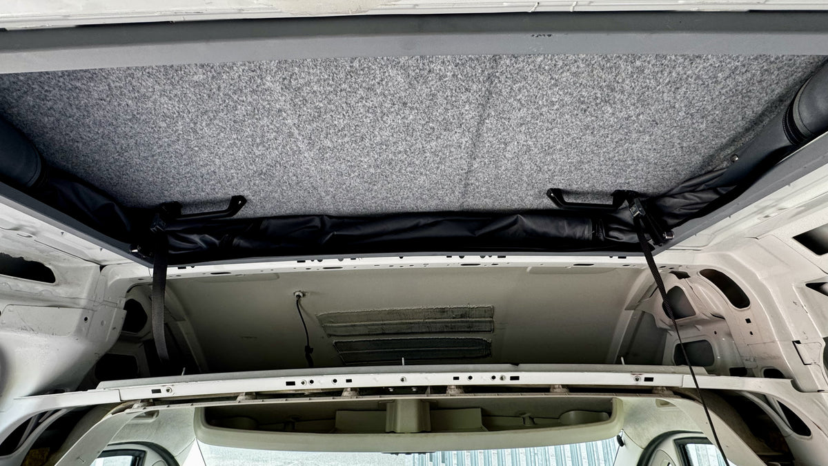 Pop-top roof opening with grey insulation liner inside the van
