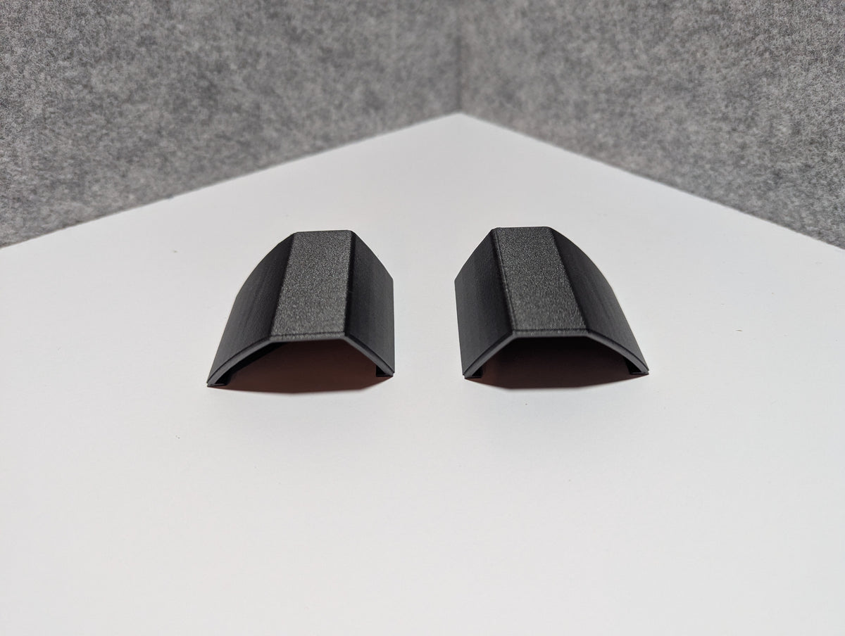 Pair of black roof rack end caps with open cradle top and rounded edges