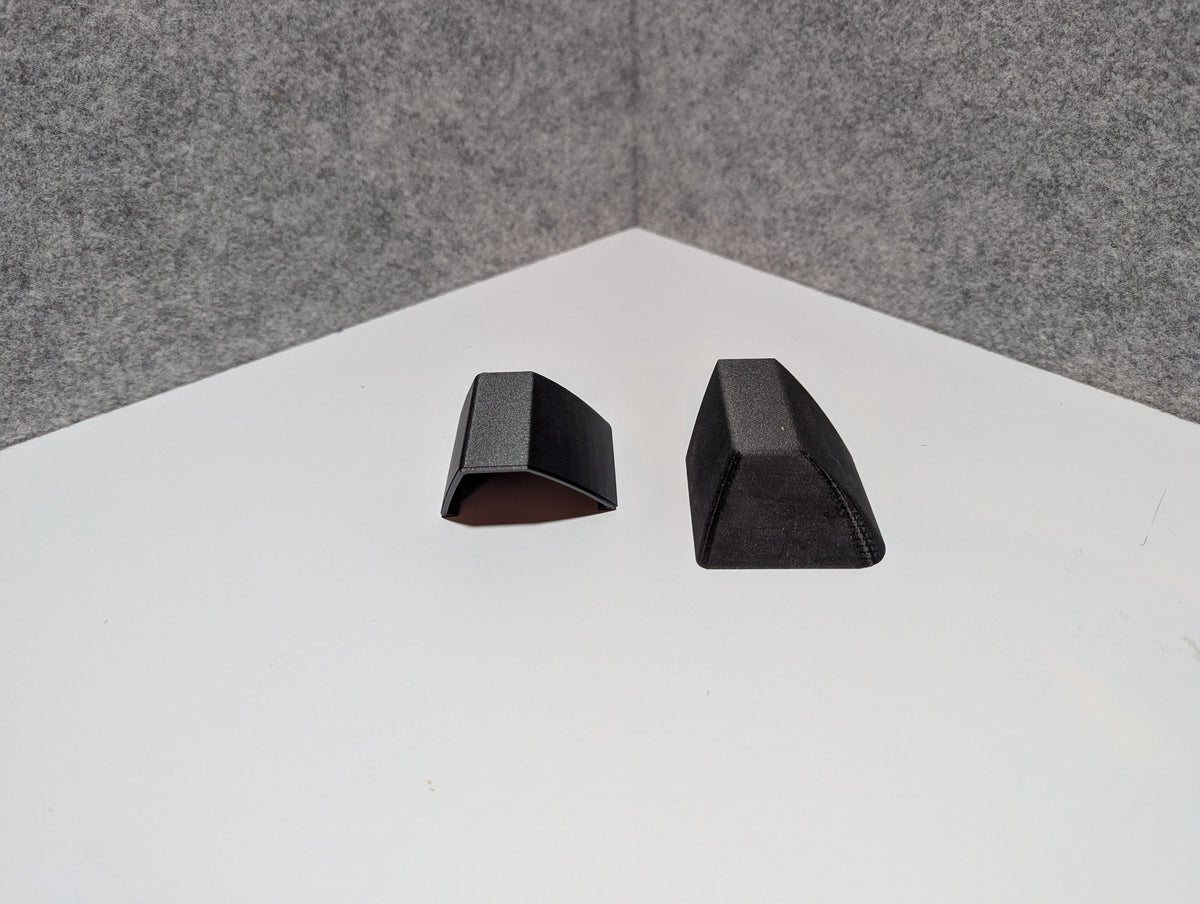 Pair of dark roof rack end caps, curved top opening