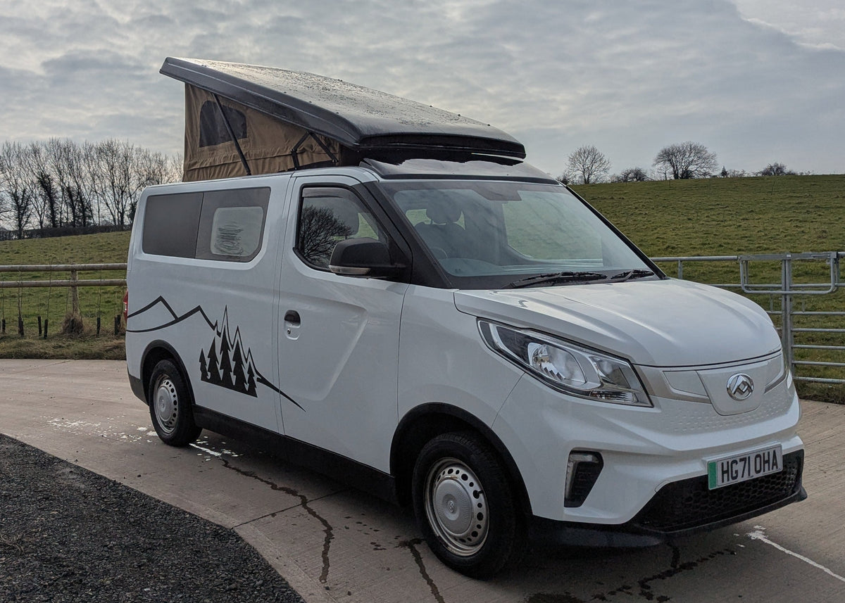 White electric campervan with open pop-top roof and black mountain side decal