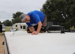 Pre-owned pre-purchase inspection service; technician checks caravan roof hatch