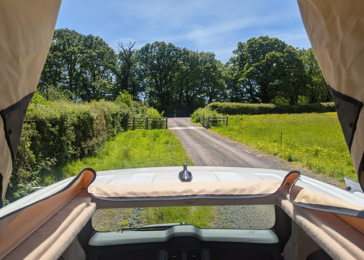 View from inside The Wyre VW ID. Buzz electric campervan with the Stargaze pop-top roof fully open, revealing a panoramic sky view — exclusive to CCCAMPERS conversions.