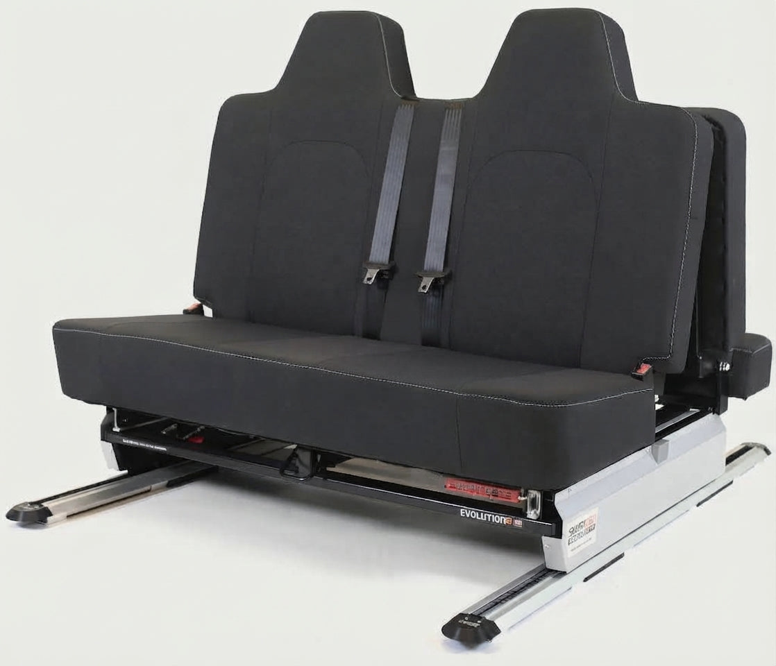 ID Buzz A black dual-row car passenger seat with integrated seat belts, mounted on a silver metal track base, photographed against a light gray studio background.