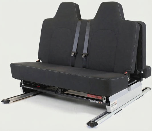 ID Buzz A black dual-row car passenger seat with integrated seat belts, mounted on a silver metal track base, photographed against a light gray studio background.