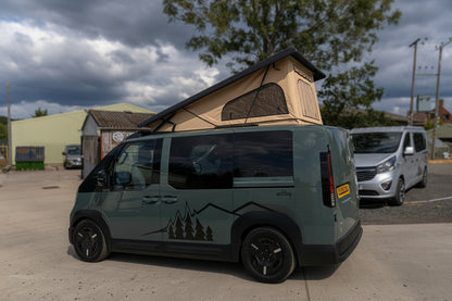 Olive Kia van with pop-top roof raised, side view with tent fabric visible