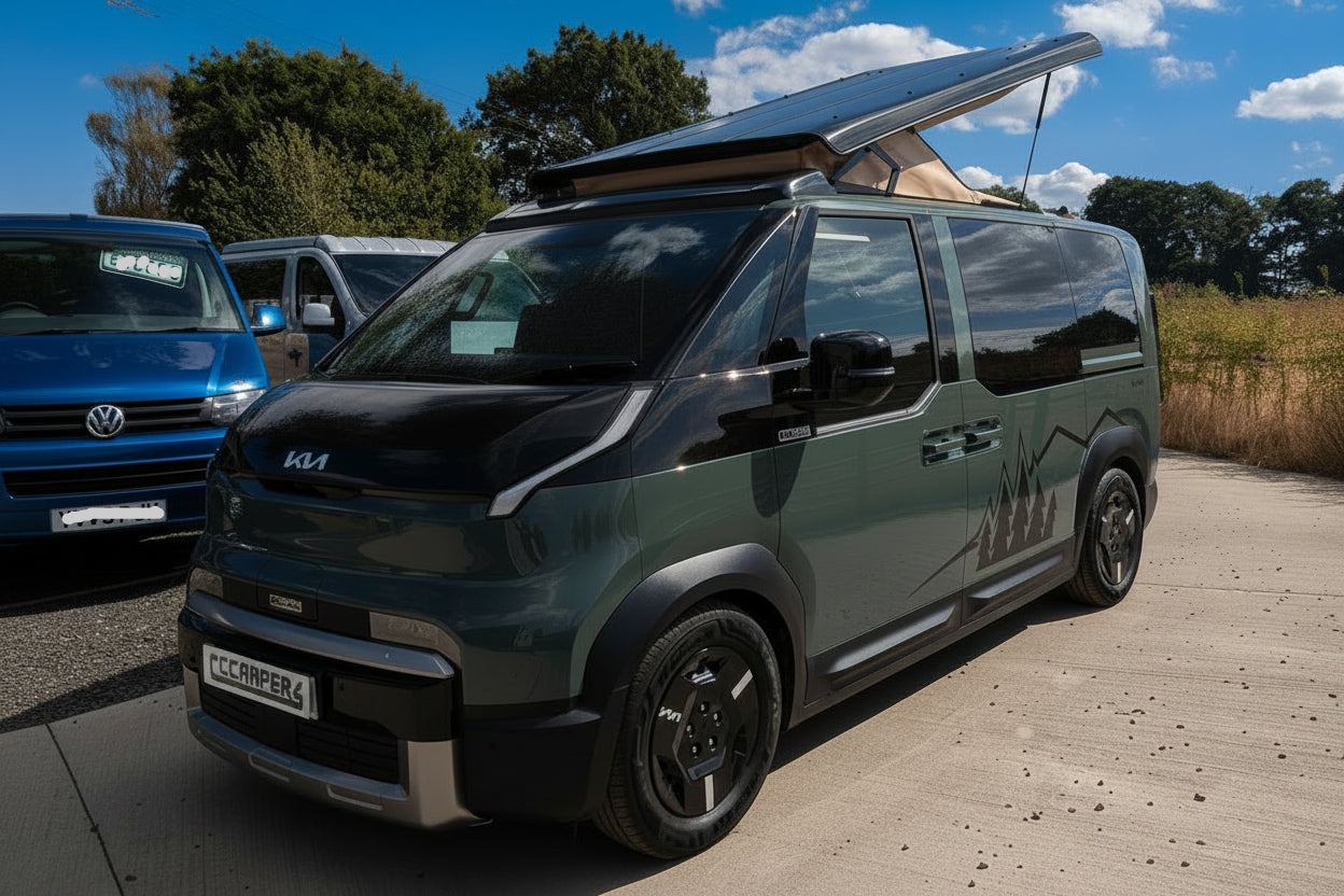 Dark Kia camper van with pop-top roof raised, front three-quarter view