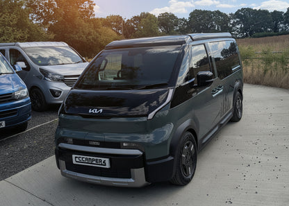 Front view of dark green Kia van camper with CCCampers pop-top roof closed