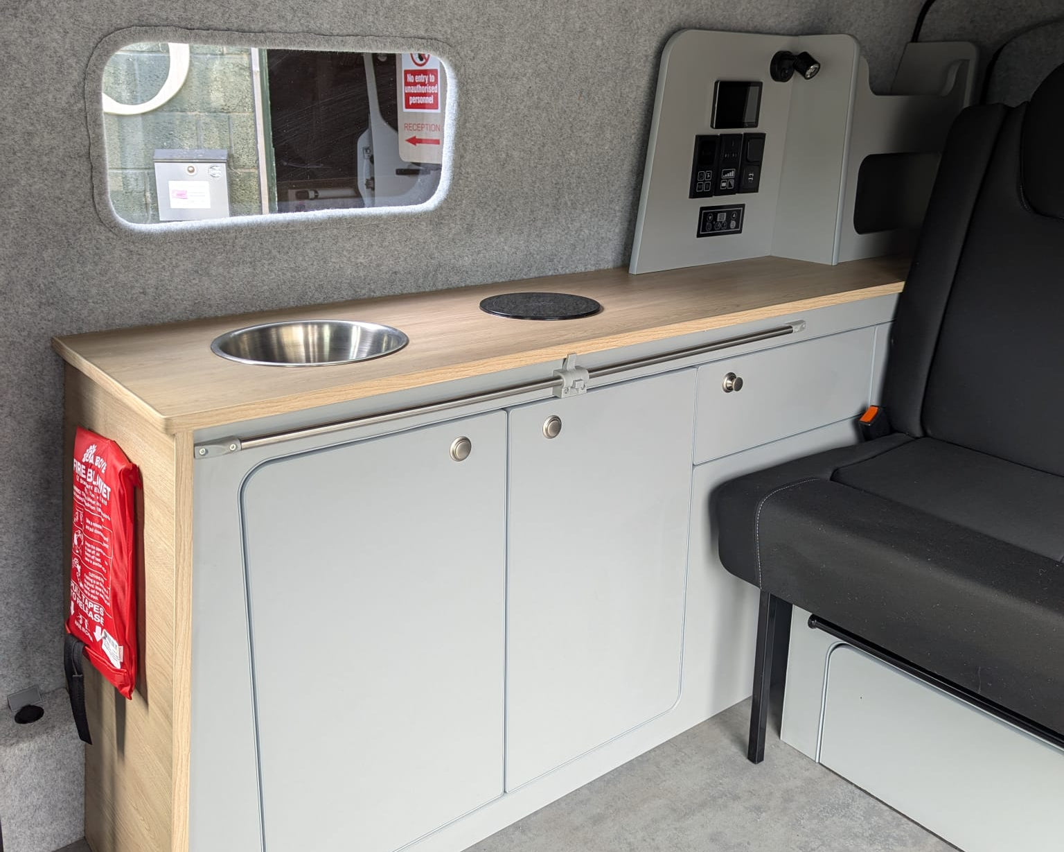 Compact kitchen area inside a Maxus eDeliver 3 with a sink, countertop, and cabinets.