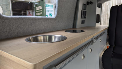 Maxus eDeliver 3 Camper van interior with wooden countertop, sink, and cabinets.