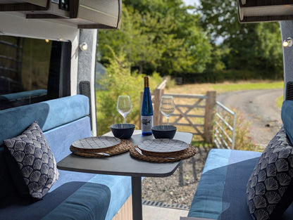 Camper van interior with table set for a meal outdoors