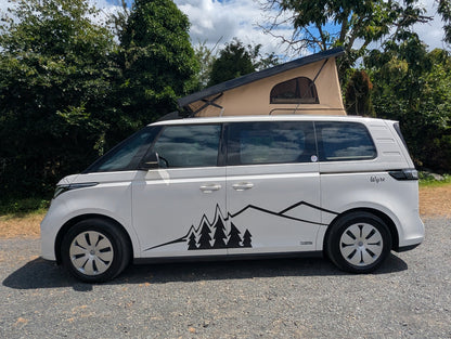 The Wyre by CCCAMPERS — white Volkswagen ID. Buzz electric campervan with Stargaze rear-elevating pop-top roof extended, parked outdoors with signature mountain and pine tree graphic decal.
