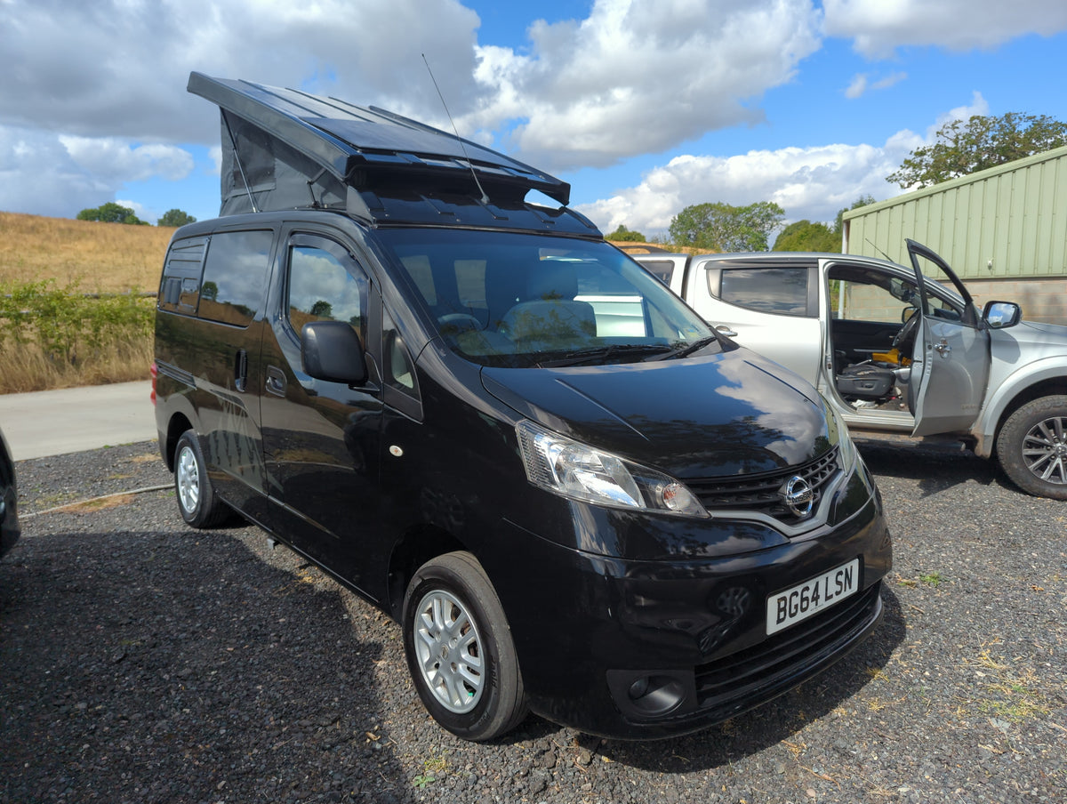 Black campervan with pop-top roof raised, front three-quarter view and open door.