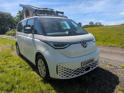 White Volkswagen van with a popped roof in a field