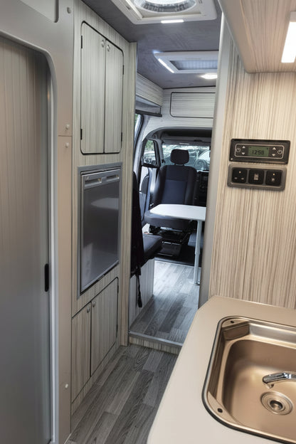 The 'Abberley' Renault Master & Nissan Interstar Campervan Conversion Service by CCCAMPERS — full interior view showing washroom door, integrated fridge, swivel cab seat, and touchscreen control panel